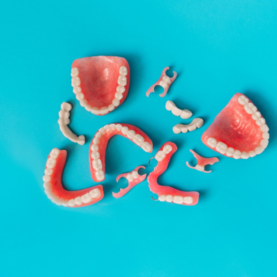 Bird’s eye view of various types of dentures on blue background