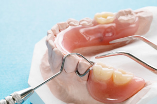 Partial dentures and dental instruments on cast of lower arch
