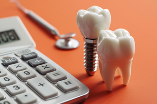 Calculator with dental implant and tooth nearby