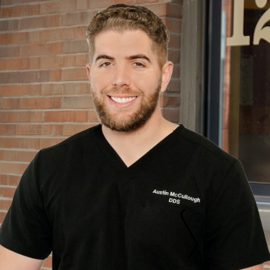 Rapid City dentist Doctor Austin McCullough smiling in black scrubs