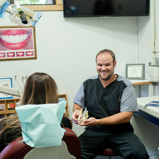 Doctor Anderson showing a model of the jaw to a dental patient