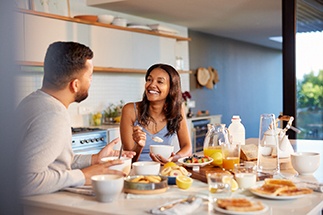 Couple smiling while enjoying meal together at home