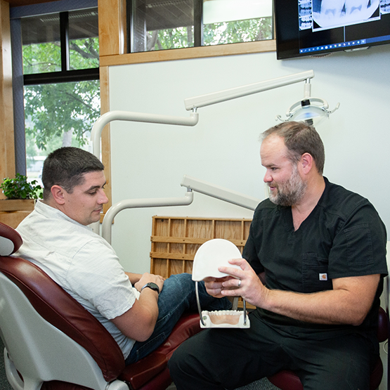 Doctor Anderson showing a patient a model of the teeth and jaws