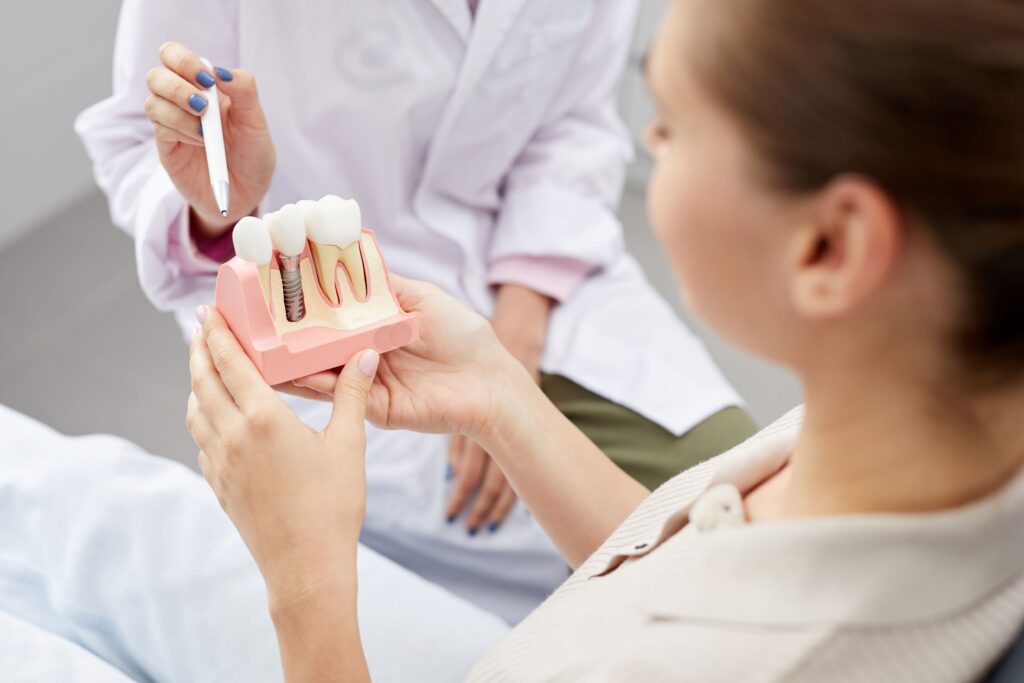 Dentist showing sample implant to patient