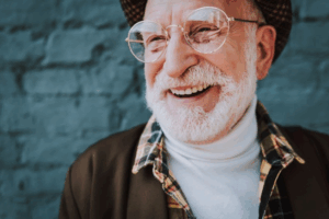 Fashionable senior smiling with blue bricks in the background